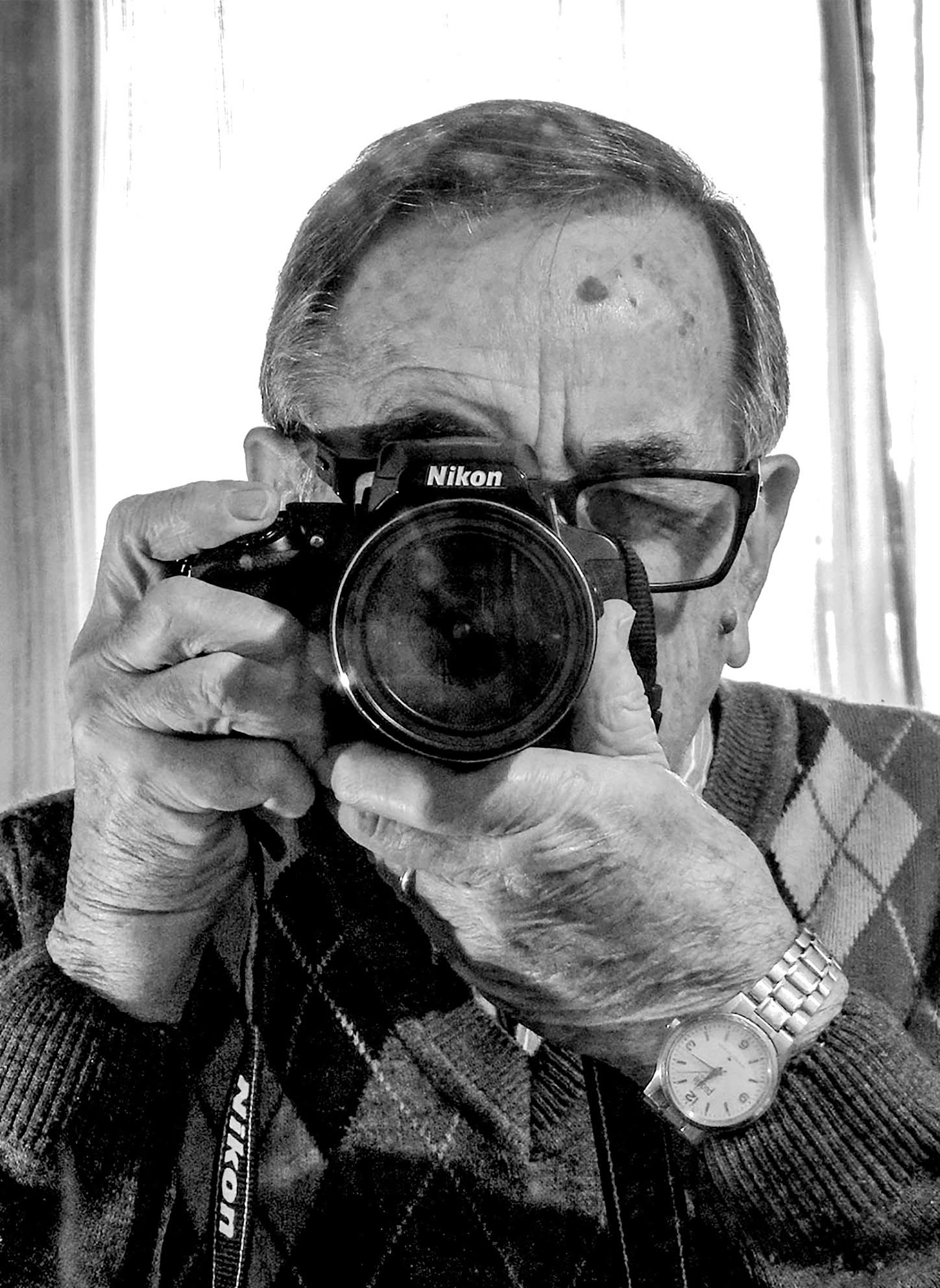 Hugo Banegas mirando por el visor de su cámara Nikon